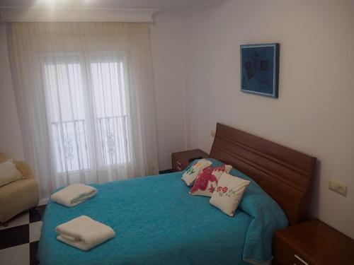 1 dormitorio con 1 cama azul y 2 almohadas en LA CASA DE SENSI en Güéjar-Sierra