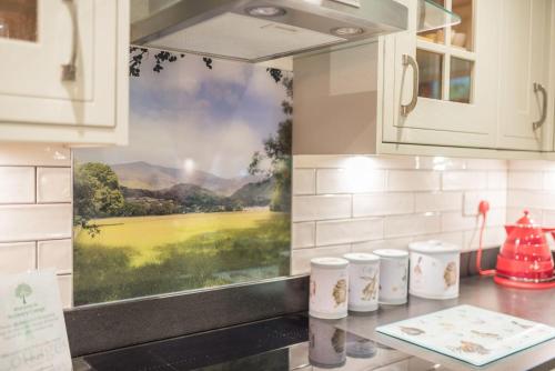 a kitchen counter with a painting on the wall at Roseberry Cottage Coniston in Coniston