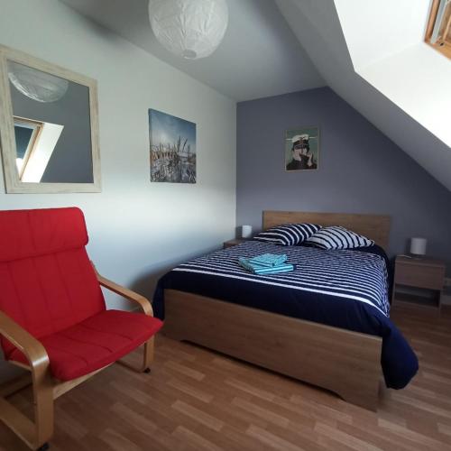 une chambre avec un lit et une chaise rouge dans l'établissement Maison 3 chambres - plages et mer, à Gâvres