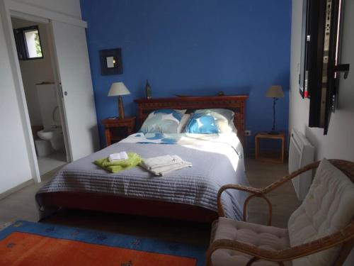 een blauwe slaapkamer met een bed en een stoel bij Beau 2 pièces avec jardin dans villa à Mougins. in Mougins