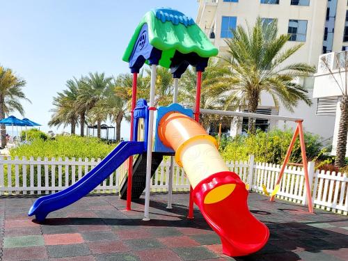 un parque infantil con un tobogán y un tobogán en Luxurious Studio Pacific Al Marjan Island - beachfront property, en Ras al Khaimah