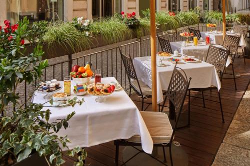 a row of tables with plates of food on a patio at Hotel Accademia in Verona