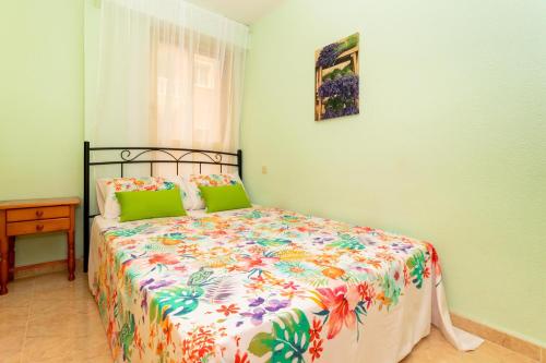 1 Schlafzimmer mit einem Bett mit Blumendecke in der Unterkunft Espanatour AMARION in Torrevieja