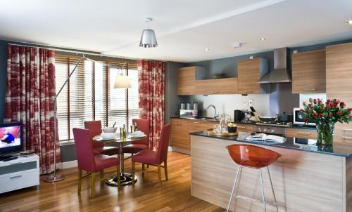 a kitchen and dining room with a table and chairs at Dreamhouse Apartments Glasgow City Centre in Glasgow