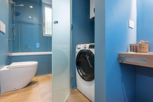 a blue bathroom with a washing machine in it at Flats4rent Carla's Apartments in Verona