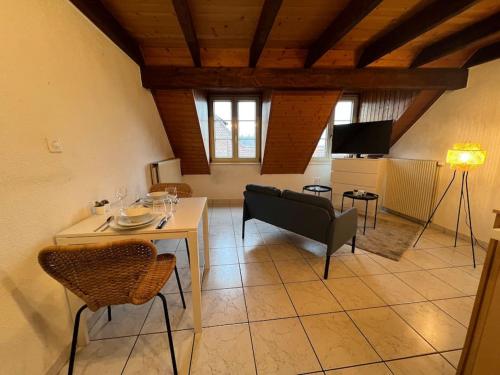 - un salon avec une table et des chaises dans l'établissement Charmant appartement en duplex à Porrentruy, à Porrentruy