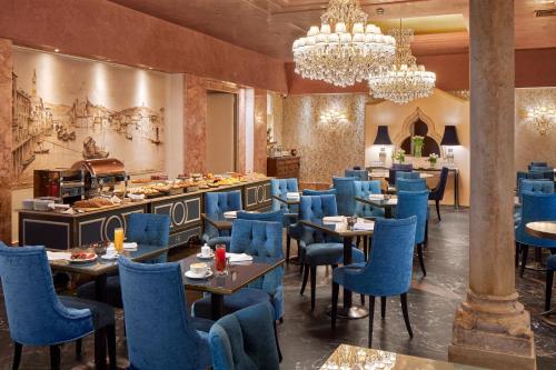 una sala da pranzo con sedie e tavoli blu di Hotel Accademia a Verona