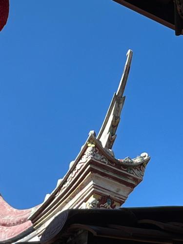 a cross on top of a building with the sky in the background at Horn Seaside Homestay in Nangan