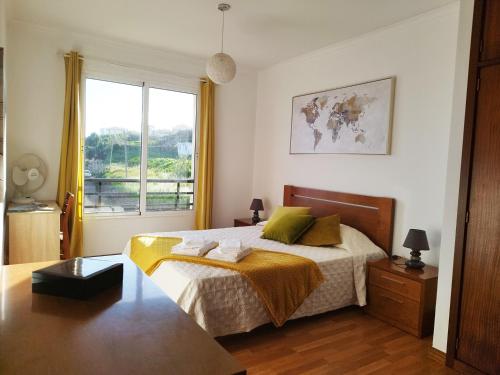 Un dormitorio con una cama grande y una ventana. en MCStylo - Varandas Falésia, en Caniço