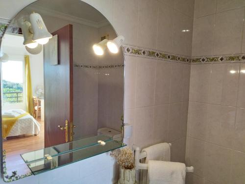 Un baño con lavabo, espejo y cama. en MCStylo - Varandas Falésia, en Caniço