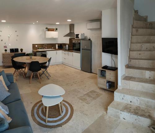 a kitchen and living room with a table and a couch at Appartement dans Mas Provencal in Arles