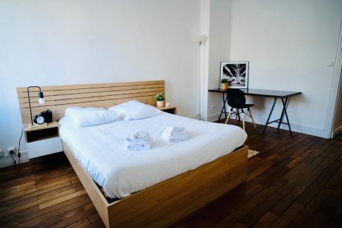 a bedroom with a large bed with a desk and a chair at City center Caen in Caen