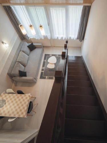 an attic room with stairs and a table and chairs at Hőforrás Hotel in Gyula