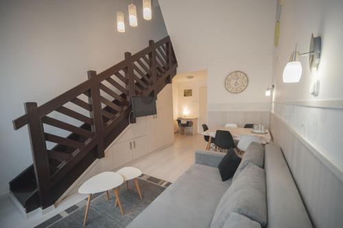 a living room with a couch and a staircase at Hőforrás Hotel in Gyula