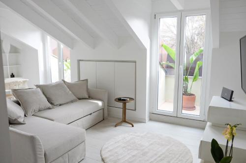 Biały salon z kanapą i oknem w obiekcie La Maison City Life Apartments w Mediolanie