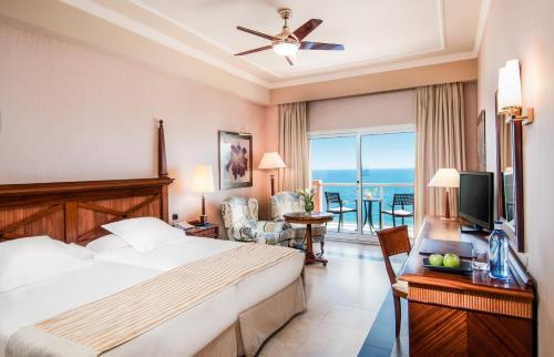 a hotel room with a bed and a view of the ocean at Elba Estepona Gran Hotel & Thalasso Spa in Estepona