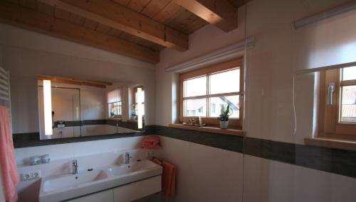 baño con 2 lavabos y espejo grande en Alpenflair Ferienwohnungen Whg 404 en Oberstdorf