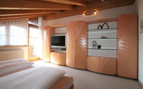a bedroom with a bed and a flat screen tv at Alpenflair Ferienwohnungen Whg 404 in Oberstdorf