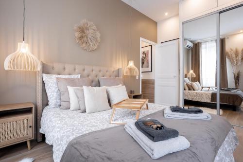 une chambre avec un grand lit avec des serviettes dessus dans l'établissement L'atelier des Artistes -Écrin de sérénité au coeur de Cannes - Balcon - Clim - Wifi, à Cannes