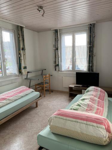 1 dormitorio con 2 camas, escritorio y ventanas en Landgasthof Adler in 9304 Bernhardzell, en Häggenschwil