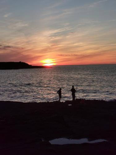 two people standing on the beach at sunset at Ocean Heights B&B in Lissadell