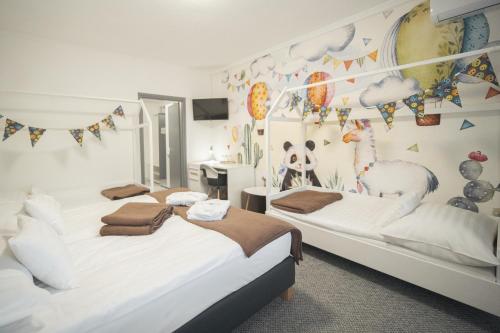 two beds in a bedroom with a wall with flags at Hőforrás Hotel in Gyula