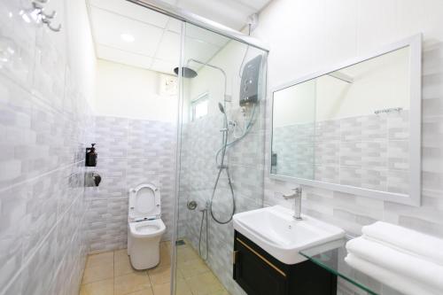 La salle de bains est pourvue de toilettes, d'un lavabo et d'une douche. dans l'établissement Rainbow Huts by Zing Motel, à Butterworth