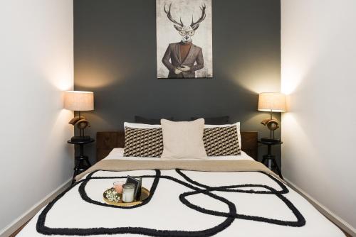 a bedroom with a bed with a antelope picture on the wall at Queen Studio by LoftAffair in Krakow