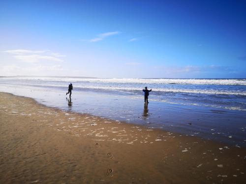two people standing on a beach near the ocean at Ocean Heights B&B in Lissadell