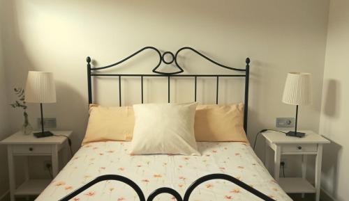 um quarto com uma cama com duas mesas e dois candeeiros em Apartamento Pozozabale em Elejalde