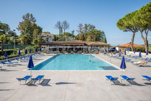 a large swimming pool with chairs and umbrellas at Il Pelagone Hotel & Golf Resort Toscana in Gavorrano