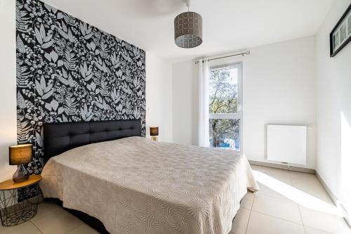 ein Schlafzimmer mit einem Bett und einer schwarz-weißen Wand in der Unterkunft Moderne, piscine, parking privé, climatisation, 3 chambres in Six-Fours-les-Plages