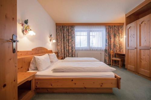 een slaapkamer met een houten bed en een raam bij Landhaus Gumpold in Neustift im Stubaital