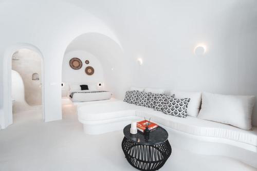 Sala de estar blanca con sofá blanco y mesa en AKRI santorini with heated jacuzzi, en Emporio