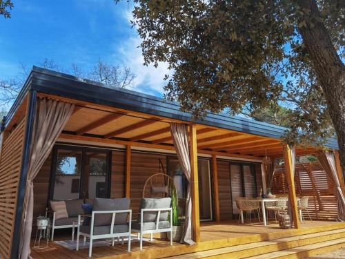 una terrazza in legno con padiglione, tavolo e sedie. di Eliška Holiday Home a Biograd na Moru