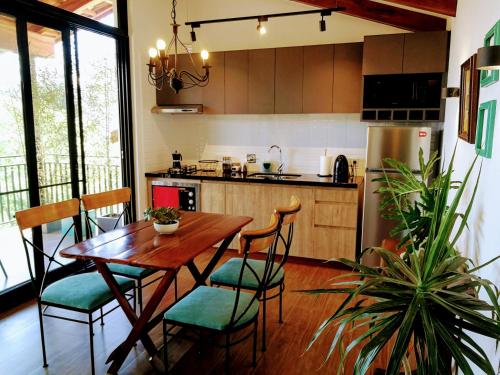 a kitchen with a wooden table and some chairs and a table at La Vista - Un lugar de Ensueño in Samaipata