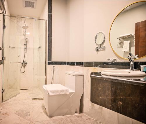 a bathroom with a shower and a toilet and a sink at sas blue suites in Jeddah