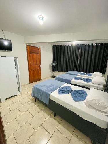 a bedroom with two beds and a tv at Hotel Brasil Anápolis Goiás in Anápolis