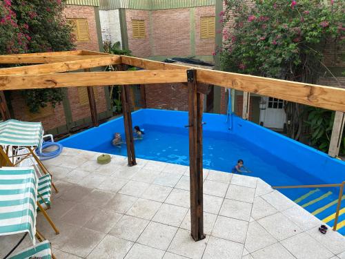 pérgola de madera sobre una piscina azul en Apart Hotel Río Dulce en Termas de Río Hondo