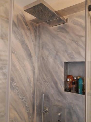 La salle de bains est pourvue d'une douche avec un mur recouvert d'aaucet. dans l'établissement Appartamento zona porto a 10 mn a piedi dal mare, à Nice