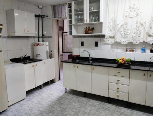 una cocina con armarios blancos y fregadero en LA CASA DE LA PARRA en Godoy Cruz