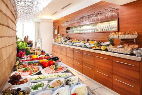 una línea de buffet con muchos platos de comida en YachtHotel Helvetia Spa- und Wellnessdomizil, en Lindau