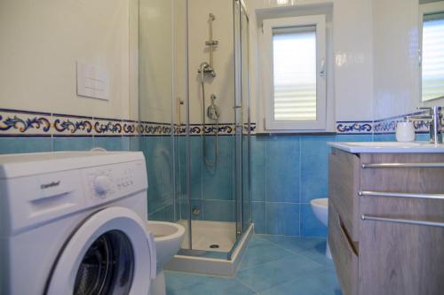 a bathroom with a washing machine and a shower at L'Incanto del Golfo li cylentos in Scario