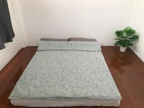 Bett in einem Zimmer mit Topfpflanze in der Unterkunft บ้านสุขใจ (Ban Suk Jai) 