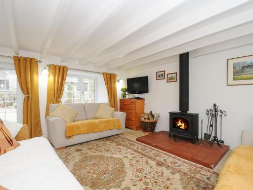 a living room with a couch and a fireplace at Henwood Barn in Liskeard