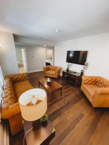 a living room with two couches and a flat screen tv at The Jefferson Inn in Southern Pines