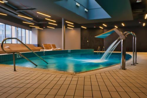 a swimming pool with a water slide in a building at Novotel Szczecin Centrum in Szczecin