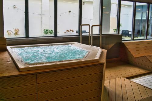a jacuzzi tub in a room with windows at Novotel Szczecin Centrum in Szczecin