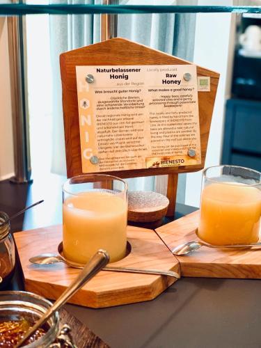 two glasses of orange juice on a wooden cutting board at Best Western Plus Atrium Hotel in Ulm