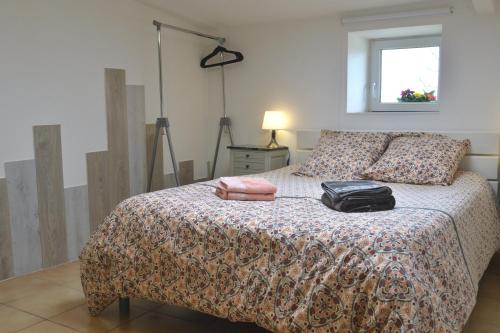 a bedroom with a bed with a bag on it at Gîte Kerlosvézan, à la campagne, proche mer in Lampaul-Ploudalmézeau